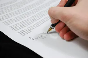 A document being signed with a fancy pen