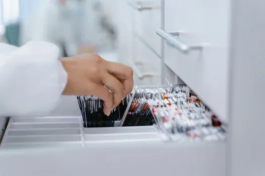 A doctor skimming through a drawer filled with bone marrow slides.